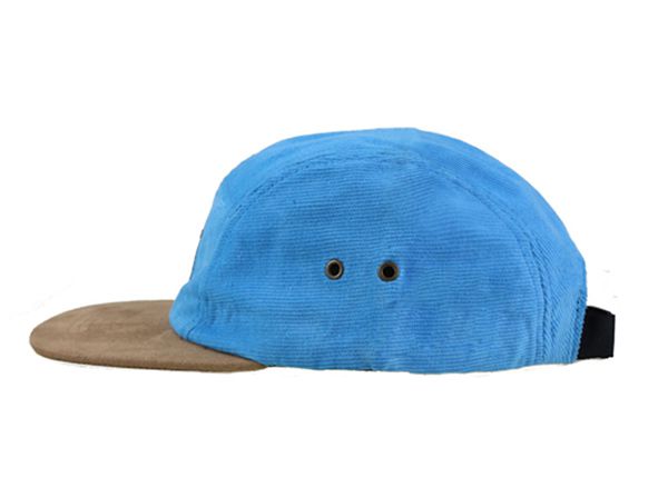 Lado del sombrero de 5 panel de azul bebé con borde de gamuza marrón y una etiqueta de cuero