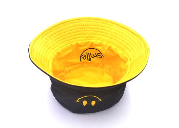 Dentro del sombrero de cubo negro reversible con un logotipo de sonrisa