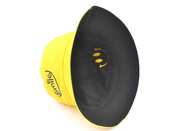 Dentro del sombrero de cubo amarillo reversible con un logo de sonrisa