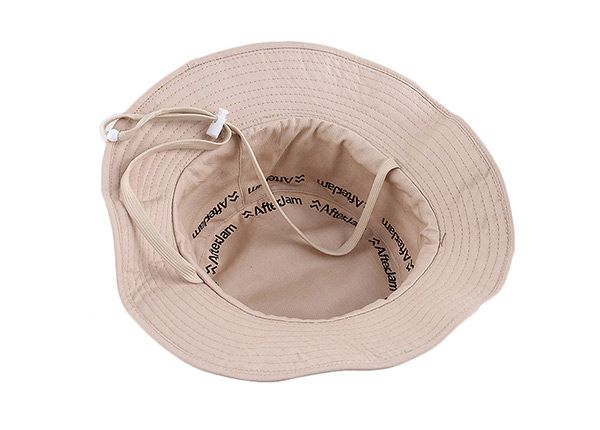 Dentro del sombrero de cubo beige de algodón reversible en blanco con cuerda